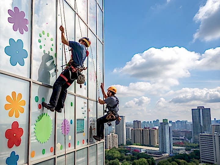 Наклейка самоклеющейся пленки промышленными альпинистами